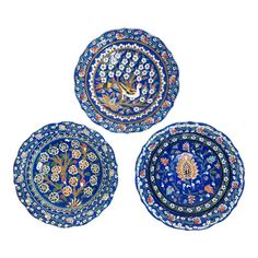 three plates with designs on them sitting side by side in front of a white background