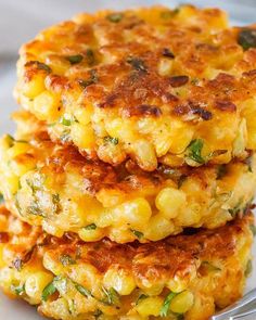 three crab cakes stacked on top of each other in front of a white plate with green leaves