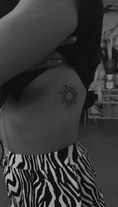 a woman with a small sun tattoo on her back