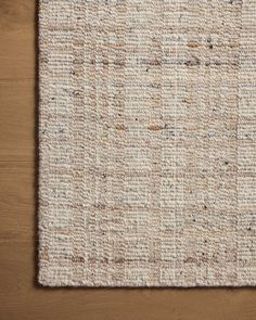 an area rug on top of a wooden floor with a brown and white checkered pattern