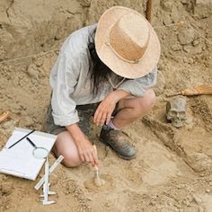 a woman kneeling down in the dirt with tools