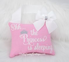 a pink pillow with a white bow on it that says she the princess is sleeping