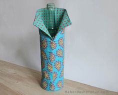 a blue vase sitting on top of a wooden table next to a white wall and floor