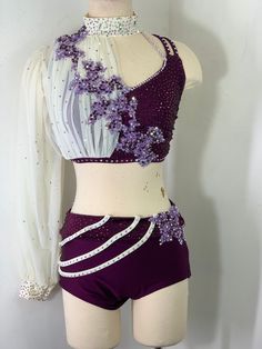 a female mannequin wearing a purple and white outfit with flowers on the top