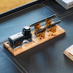 a wooden cutting board topped with scissors and combs on top of a table next to a book