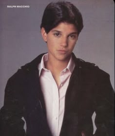 a young man wearing a black jacket and white shirt