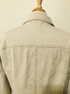 "Nice striped jacket with pockets. The jacket is a very light cream color and the stripes are a darker khaki color. The pockets each have a button in the middle. Closes and opens with buttons. Has a faux eye where you would put a button but it is only there as design. Also has three buttons on each sleeve. The jacket is lightweight and is very beautiful! Made of cotton and is in great condition! Measurements: armpit to armpit: 44\" waist: 42\" lenght: 22\" sleeves: 24\" Genesis Vintage Shop acce Casual Striped Outerwear With Buttons, Striped Button-up Outerwear With Pockets, Striped Button-up Outerwear With Button Closure, Classic Striped Button-up Outerwear, Light Cream Color, Vintage Cloth, Jacket With Pockets, Striped Jacket, Spring Jackets