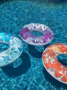 three inflatable floats floating on top of a swimming pool