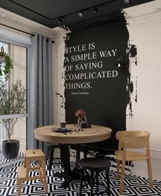 a black and white dining room with a quote painted on the wall next to two chairs