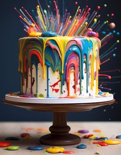 a multicolored cake with sprinkles on it sitting on a table