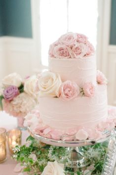 a three tiered wedding cake with pink and white flowers