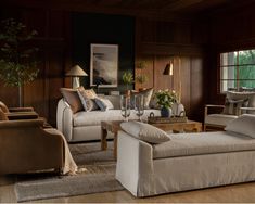 a living room with two couches, chairs and a coffee table in front of a window