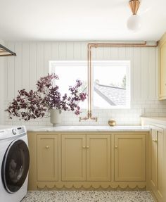 a washer and dryer in a small room with white tile flooring on the walls