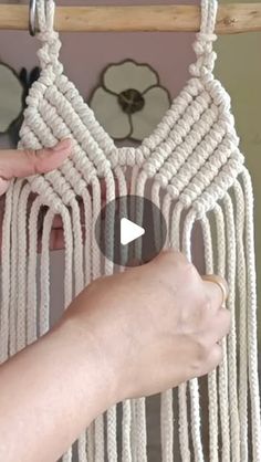 a person is holding up a white macrame