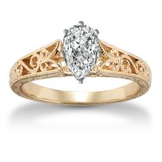 a yellow gold engagement ring with a pear shaped diamond in the center and filigrees on the sides