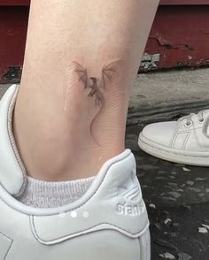 a woman's foot with a small tattoo on it