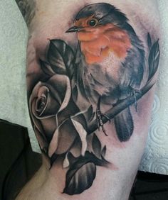 a small bird sitting on top of a branch with leaves and flowers around it's neck