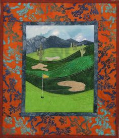 a quilted wall hanging with an image of a golf course and mountains in the background