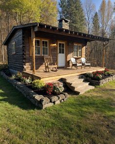 a small log cabin sitting on top of a lush green field