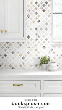 a kitchen with white cabinets and tile backsplash