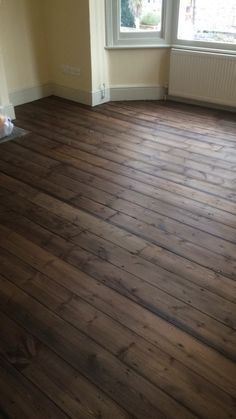 an empty room with wood floors and a window