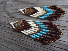 two pairs of beaded earrings sitting on top of a wooden table