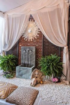 a living room with some plants and a fire place in the corner on top of it