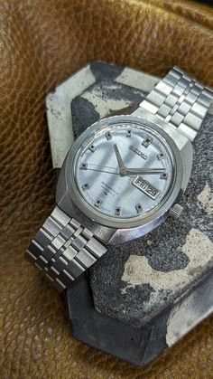 This is a vintage 1969 Seiko Seikomatic-P 33 jewel automatic men's watch reference 5106-7010. This is an extremely cool timepiece. The angular oval all-stainless steel case paired with its silver dial and indices give this watch a space-age aesthetic while retaining a classic charm.  This watch features a high grade Seiko Suwa 33 jewel automatic movement which is running great. It has an interesting quick set date feature (the day must be manually progressed) which sets by firmly pushing the cro Retro Silver Watch Accessories With Subdials, Silver Retro Watch Accessories With Subdials, Retro Analog Watch For Anniversary, Retro Silver Watch Accessories For Anniversary, Retro Automatic Watch Accessories For Anniversary, Silver Retro Collectible Watch, Retro Automatic Silver Watches, Retro Silver Automatic Watch, Silver Retro Automatic Watch