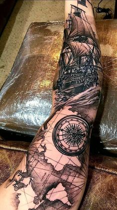 a person's foot with a compass and ship tattoo on the top of it