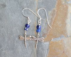 These sterling silver, dragonfly earrings are unique and dangly. These lapis lazuli earrings feature sterling silver charms with a pretty, delicate, dragonfly design.  The charms measure just over .5 in. in length. I accented these blue earrings with natural stone, lapis lazuli beads.  They are vibrant blue in color, cube shaped, and faceted. These dangly earrings are finished with sterling silver, French ear wires. Length:  just over 1.75 in. See the last photo for scale. Click here to return t Nickel-free Dragonfly Sterling Silver Earrings, Nickel-free Sterling Silver Dragonfly Earrings, Dragonfly-shaped Pierced Earrings As Gift, Nickel-free Blue Dragonfly Jewelry, Hypoallergenic Dragonfly Earrings As A Gift, Hypoallergenic Dragonfly Earrings For Gift, Color Cube, Dragonfly Design, Dragonfly Jewelry