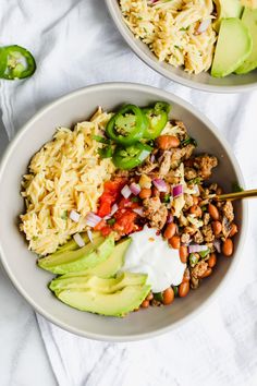 two bowls filled with different types of food on top of a white table next to each other