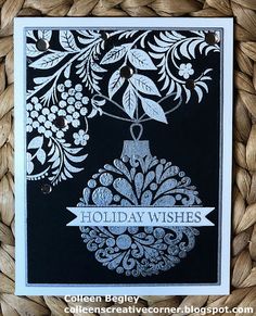 a black and white holiday card with an ornament hanging from it's side