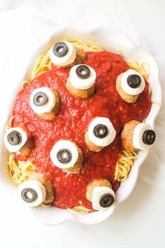 an overhead view of spaghetti with googly eyes and eyeballs in the middle for halloween