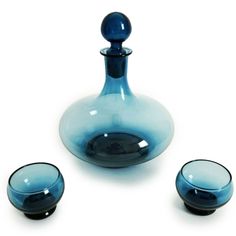 a blue glass vase with three bowls around it