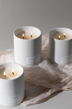 three white candles sitting on top of a table