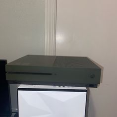 a computer monitor sitting on top of a desk next to a keyboard and mouse in front of a white wall