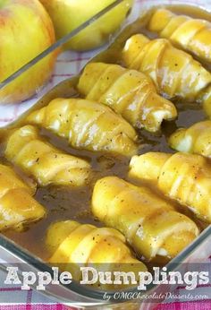 an apple dumpling in a glass dish next to apples