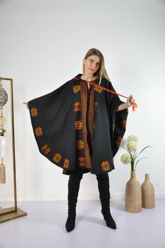 This vintage cape jacket is definitely a vintage fashion statement. It is 100% hand embroidered with geometrical patterns. It can be used over a jeans and shirt or sweater. Great to keep you warm. Please note that the capes we have at the moment (Option #1 and Option #2) are without a hoodie but they are just as beautiful and practical. Material : Wool Length : 49 inches Size : One size fits all. We ship your order with DHL express within one to two business days. Orders to Europe will typically Hooded Winter Cape For Costumes, Hooded Winter Cape For Costume Events, Traditional Hooded Winter Poncho, Traditional One Size Hooded Poncho, Winter Festival Shawl Outerwear, Oversized Bohemian Winter Cape, Traditional Wool Poncho For Winter, Traditional Hooded Winter Outerwear, Traditional One-size Cape For Fall