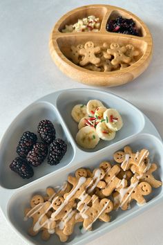 a plate with cookies, fruit and other food items on it next to a wooden bowl