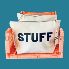 an orange and white bag with the word stuff on it in front of a blue background