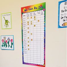 a bulletin board with children's drawings and pictures on the wall next to it