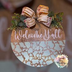 a wooden sign that says welcome y'all with bows on it and flowers in the center