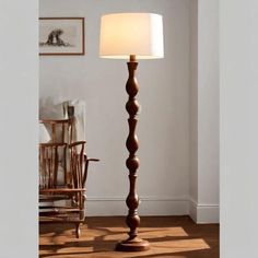 a lamp that is on top of a wooden floor next to a chair and table