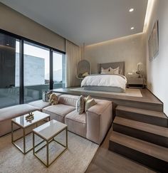 a modern bedroom with stairs leading up to the bed and sitting area in front of it