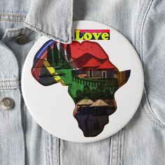 a button with the shape of africa on it that says love in front of a blue jean jacket