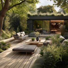 an outdoor living area with couches, tables and plants on the decked patio