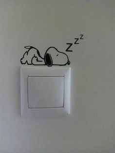 a wall mounted light switch with a sleeping dog on it