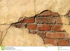 a brick wall that has been cracked in half with the paint chipping off it