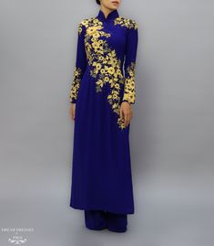 Blue and gold have never looked more stylish, and elegant, than on our stunning Mara Ao Dai bridal gown. The deep, navy blue hue accentuates the golden lace embellishments that adorn the sleeves, shoulders, and bodice; a majestic pop of color! The floral pattern is a timeless design, and the delicate crystals add a sparkle and shimmer to the golden accents. Navy Ao Dai with gold lace embellishments Collar: 1.8''/4.5cm Long sleeves Zipper closure Chiffon pants Traditional length front and back Ma Formal Wedding Guest Attire, Ao Dai Vietnamese, Vietnamese Wedding, Chiffon Pants, Golden Lace, Bridal Dresses Lace, Dream Dresses, Guest Attire, Traditional Wedding Dresses