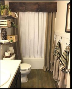 a bathroom with a toilet, sink and shower curtain in it's window sill